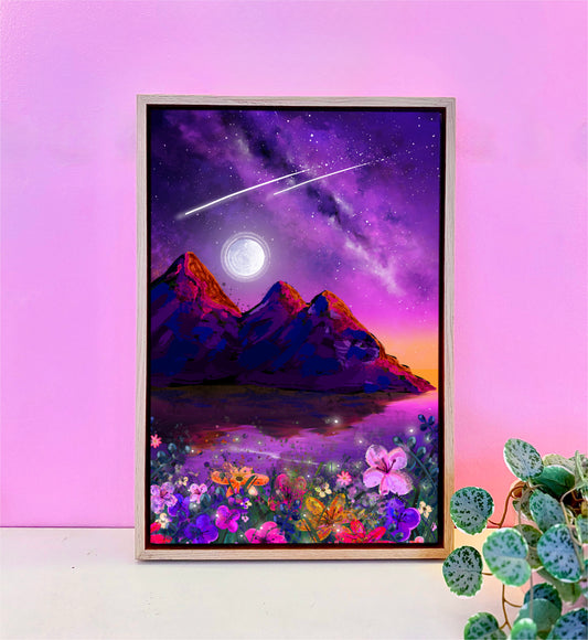 Framed artwork of a mountain landscape with a purple sky, stars, and flowers on a pink wall.