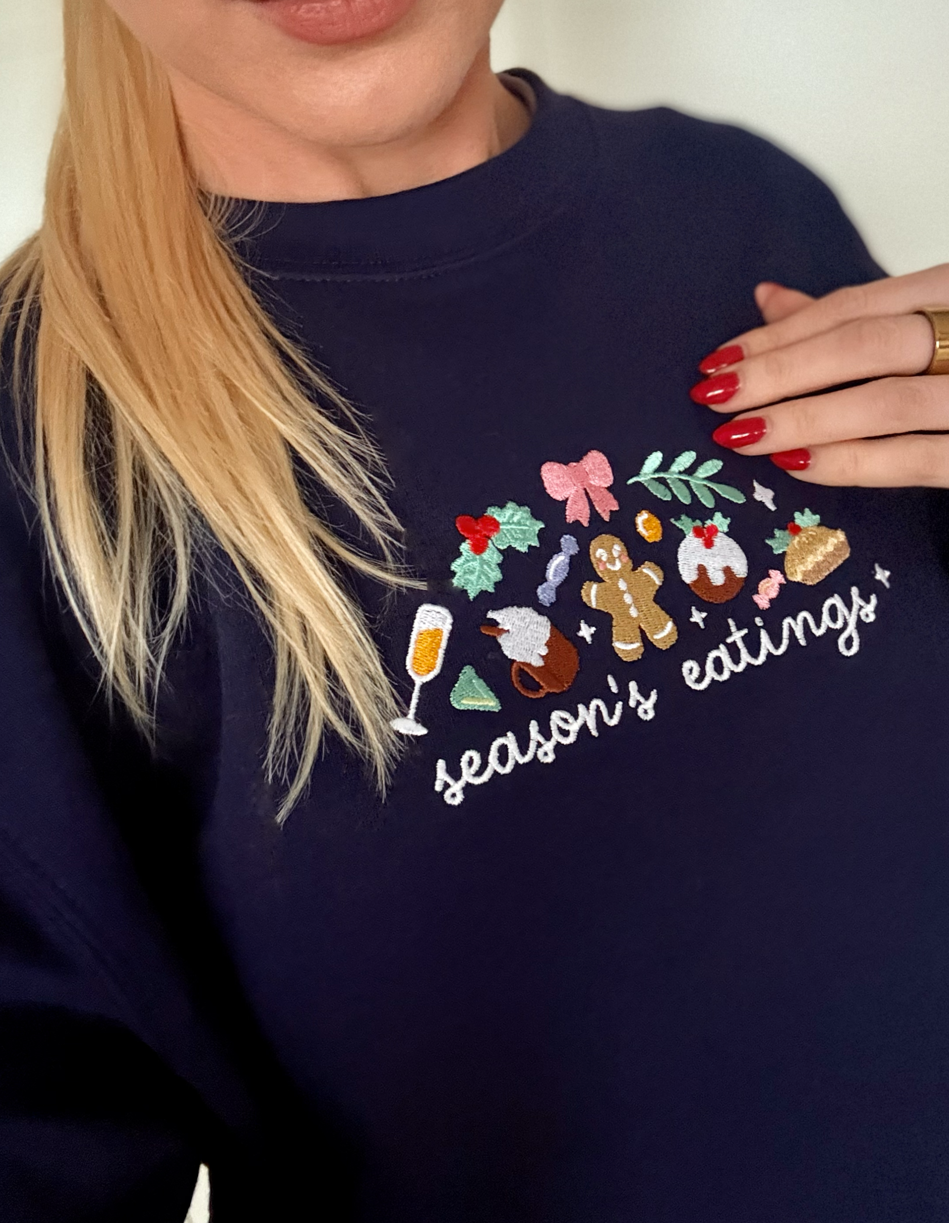 Navy blue sweatshirt with festive design and 'season's eatings' text