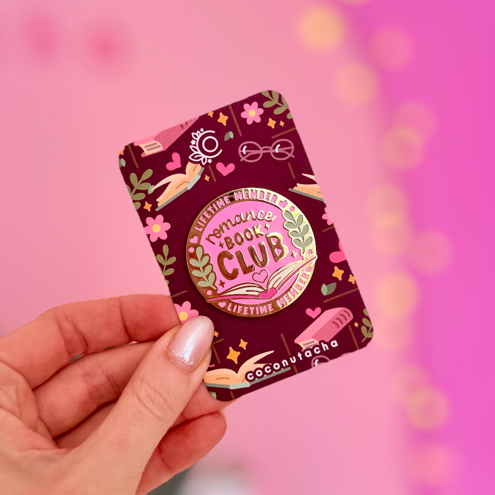 Hand holding a book club chocolate bar against a pink background