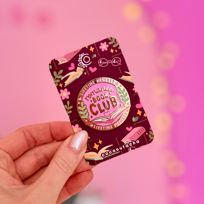 Hand holding a book club chocolate bar against a pink background