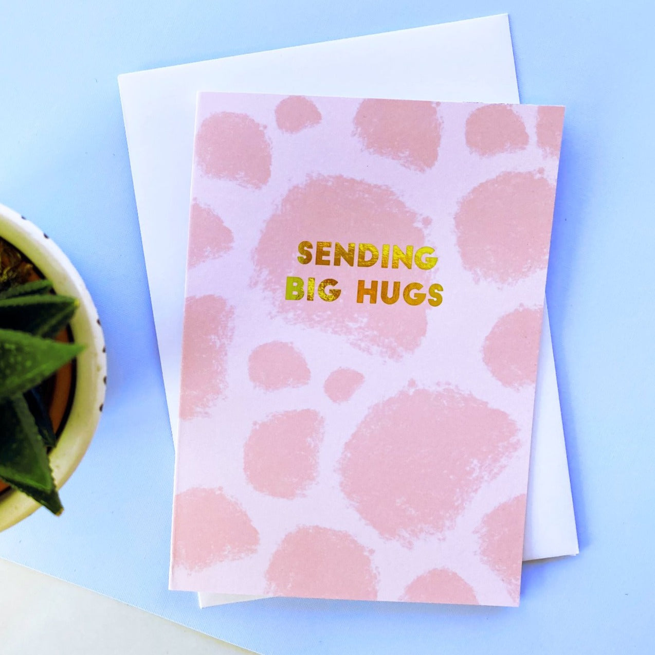 sending big hugs greeting card. pink with gold foil simple text.